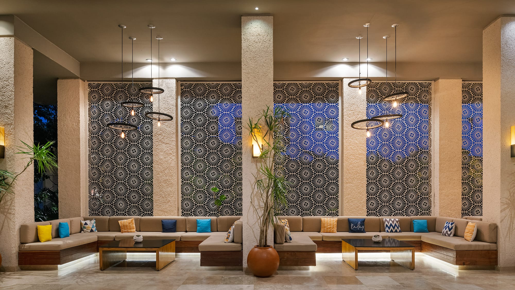 a room with a large couch and a plant in a pot