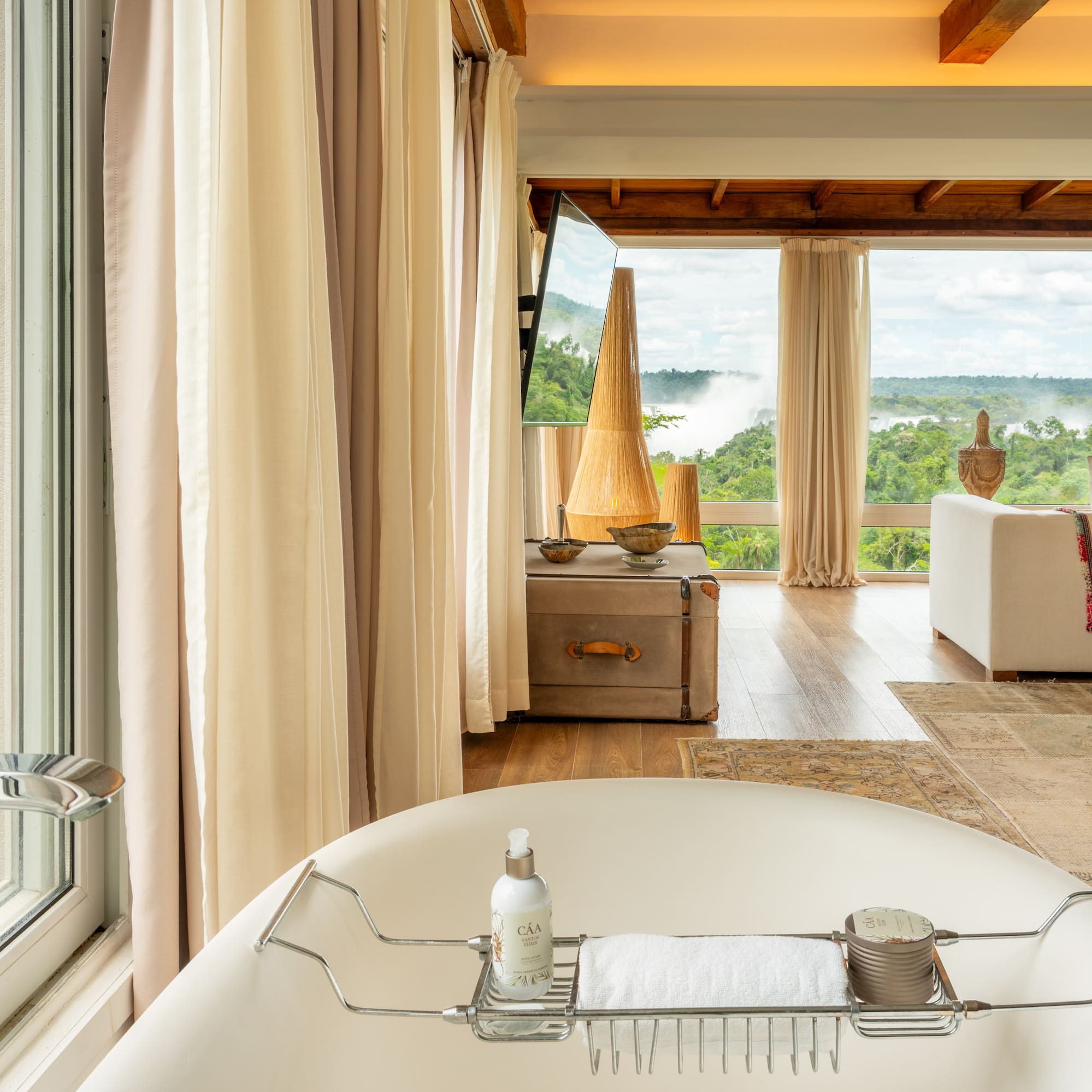 a bathtub in a room with a view of the river and a couch