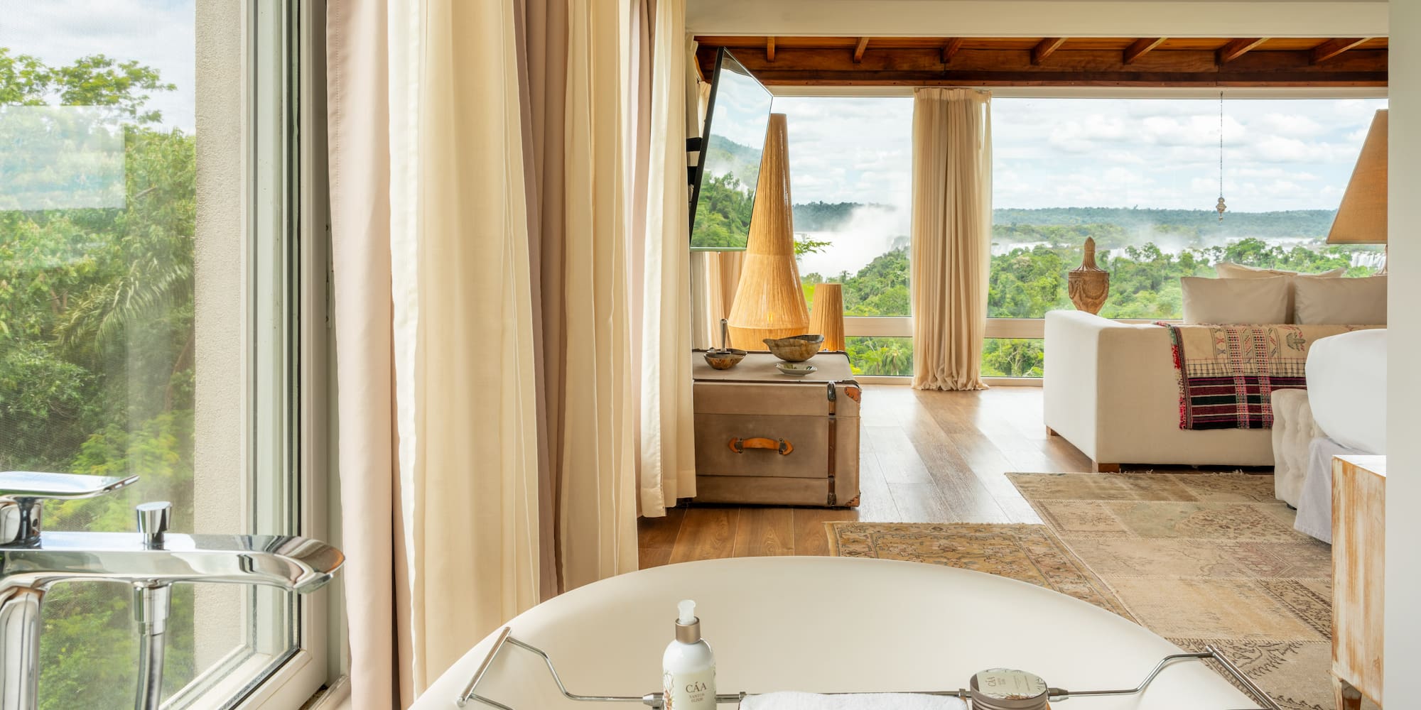a bathtub in a room with a view of the river and a couch