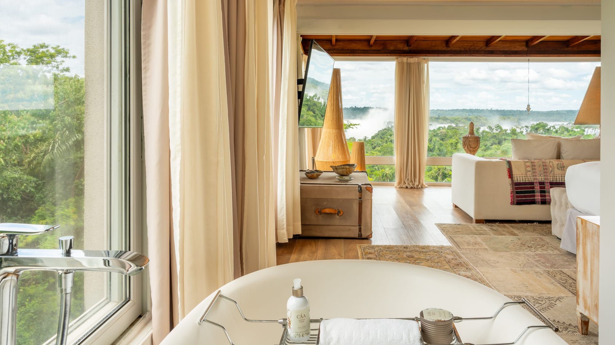 a bathtub in a room with a view of the river and a couch