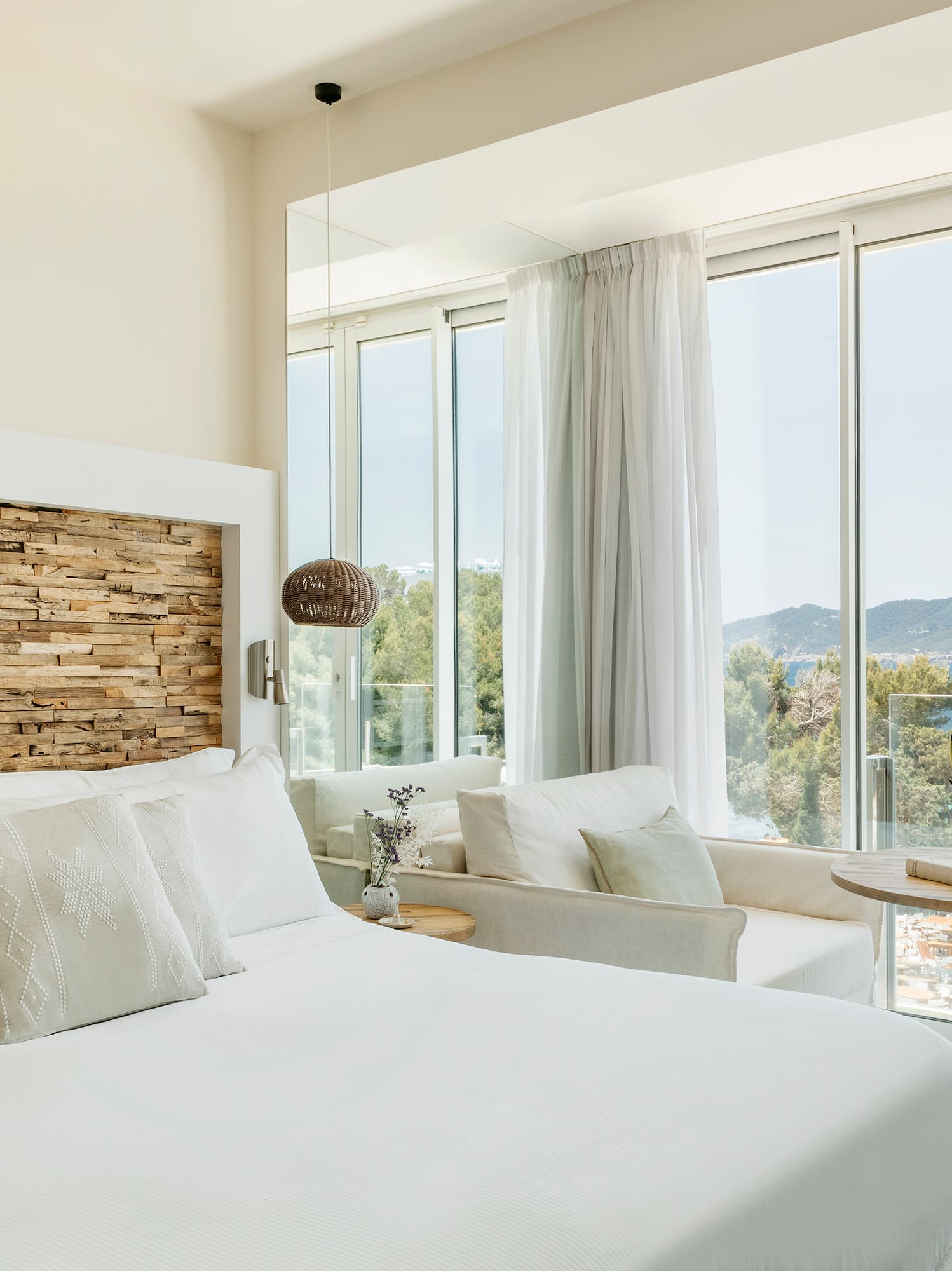 a bedroom with a large window overlooking a body of water