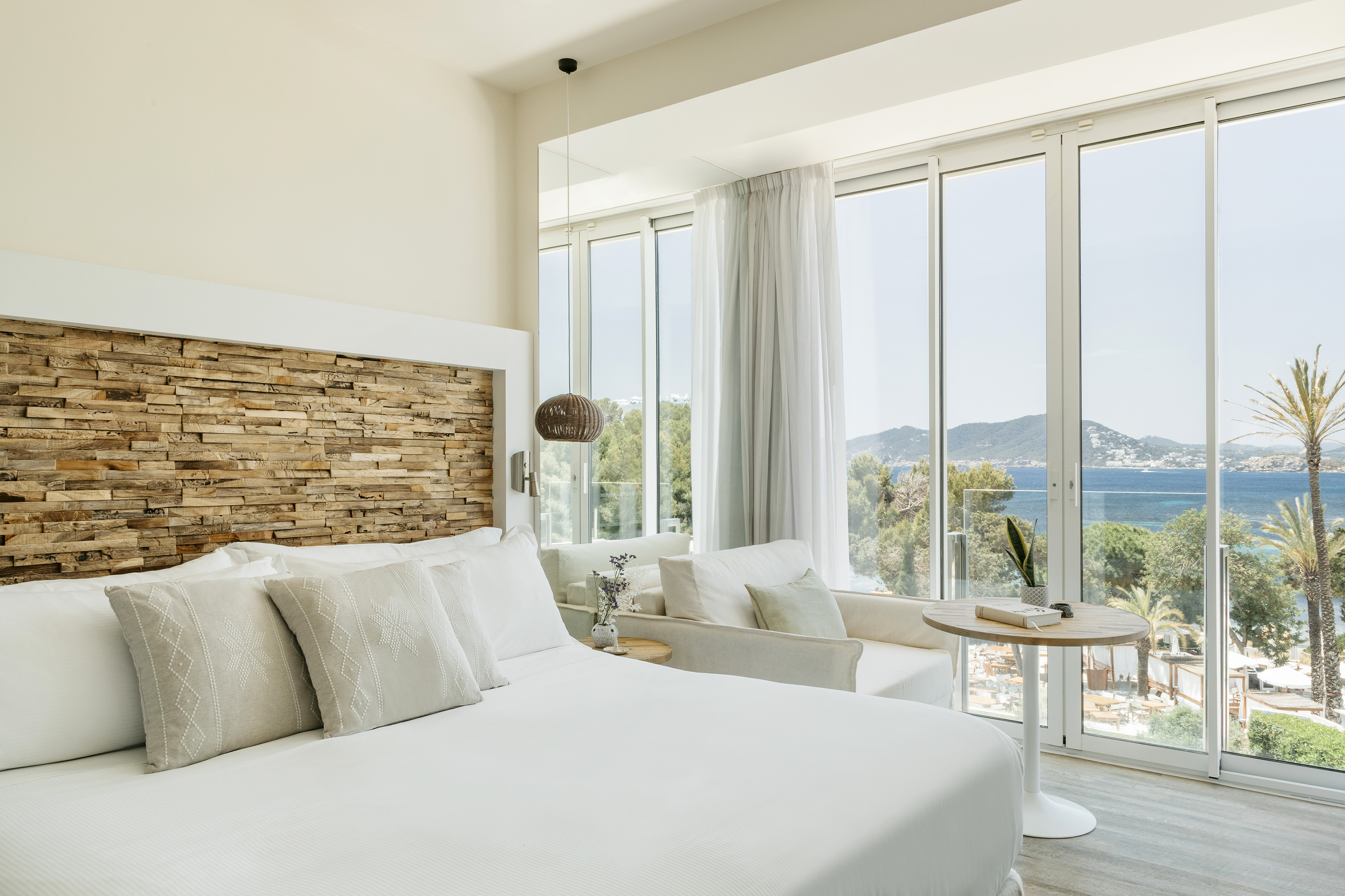 a bedroom with a large window overlooking a body of water