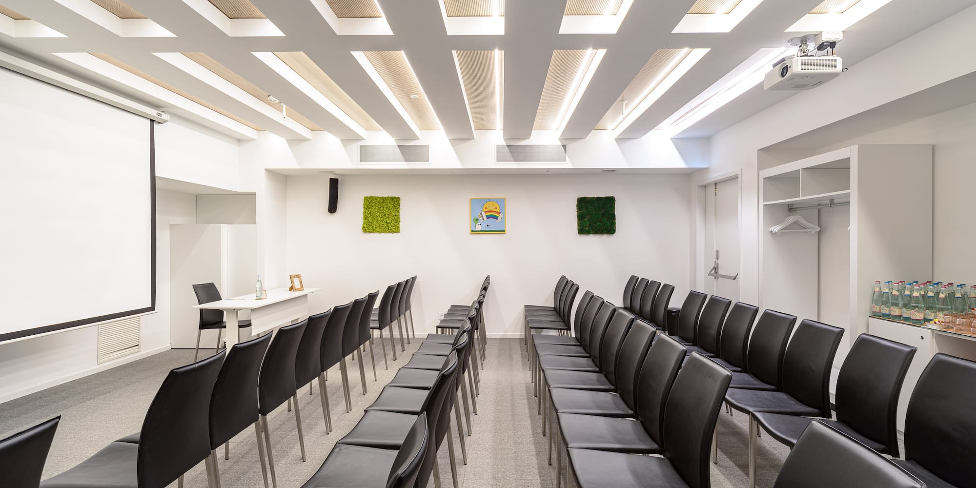 a room with black chairs and a white wall