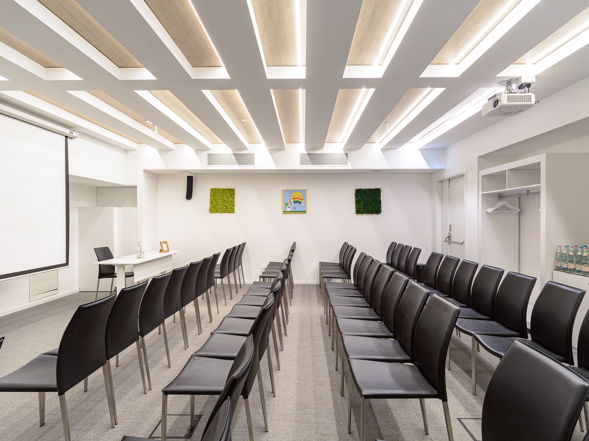 a room with black chairs and a white wall