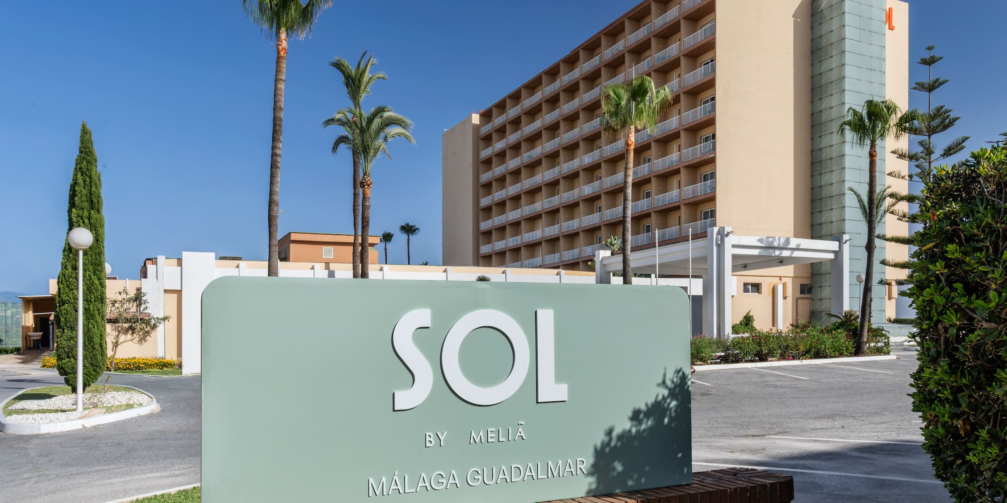 Sol by Meliã Málaga Guadalmar hotel sign, palm trees, and building exterior.