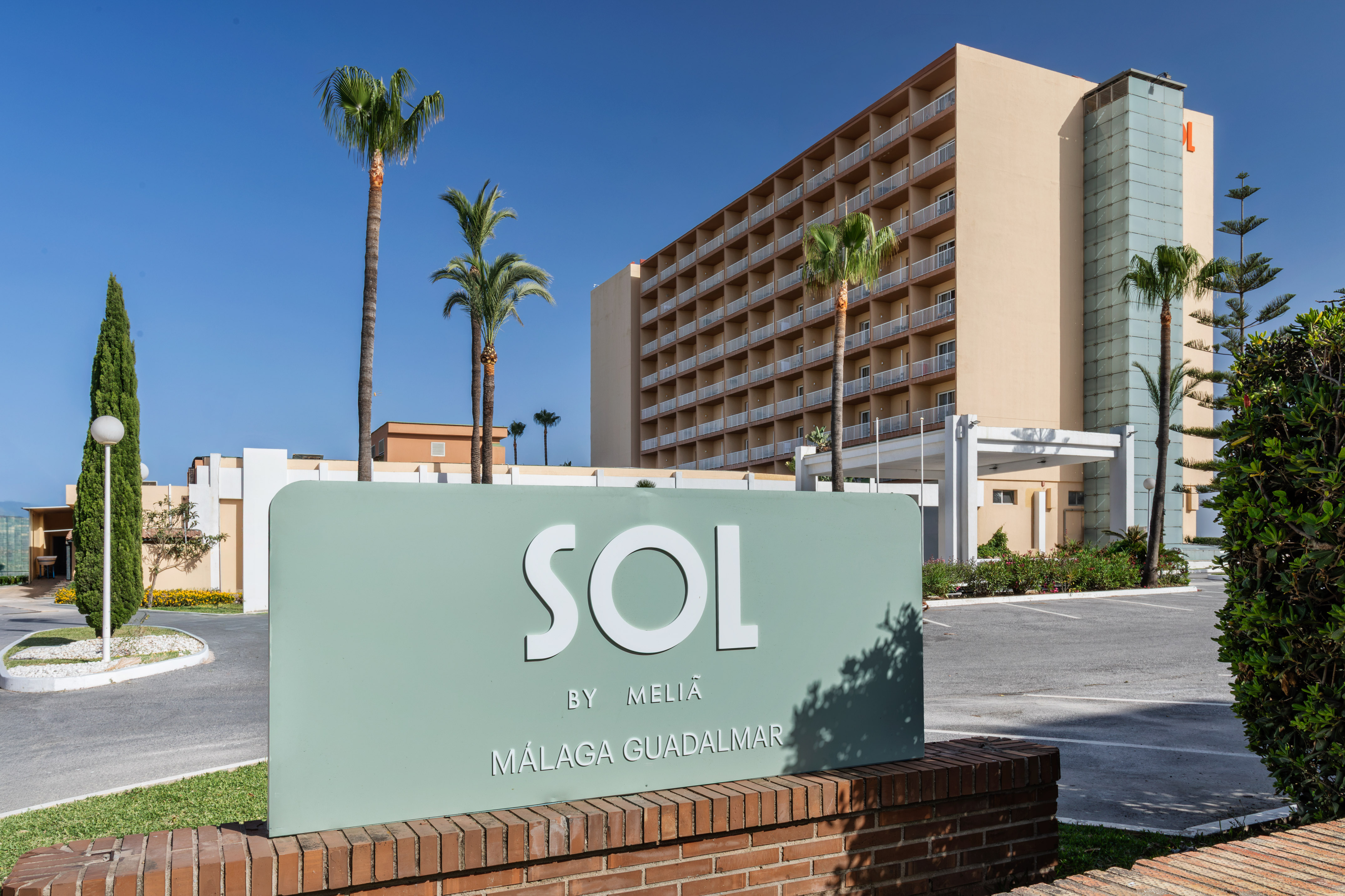 Sol by Meliã Málaga Guadalmar hotel sign, palm trees, and building exterior.