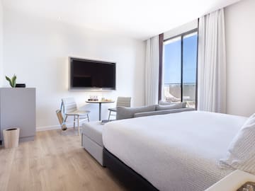 a room with a bed and a television