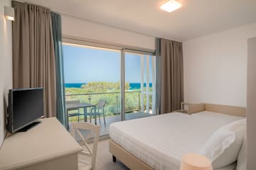 a bedroom with a table and chairs and a table and a television