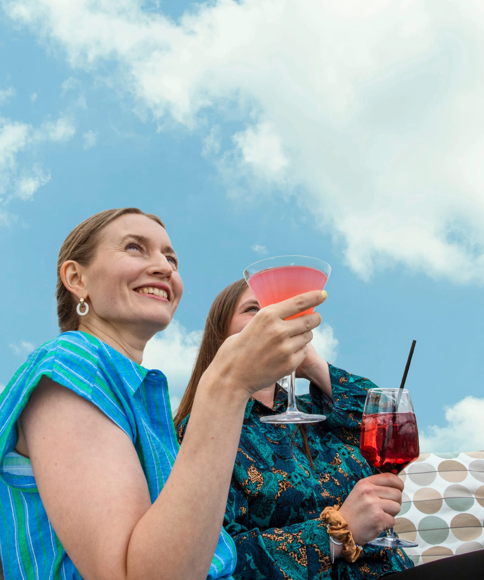 a couple of women holding drinks
