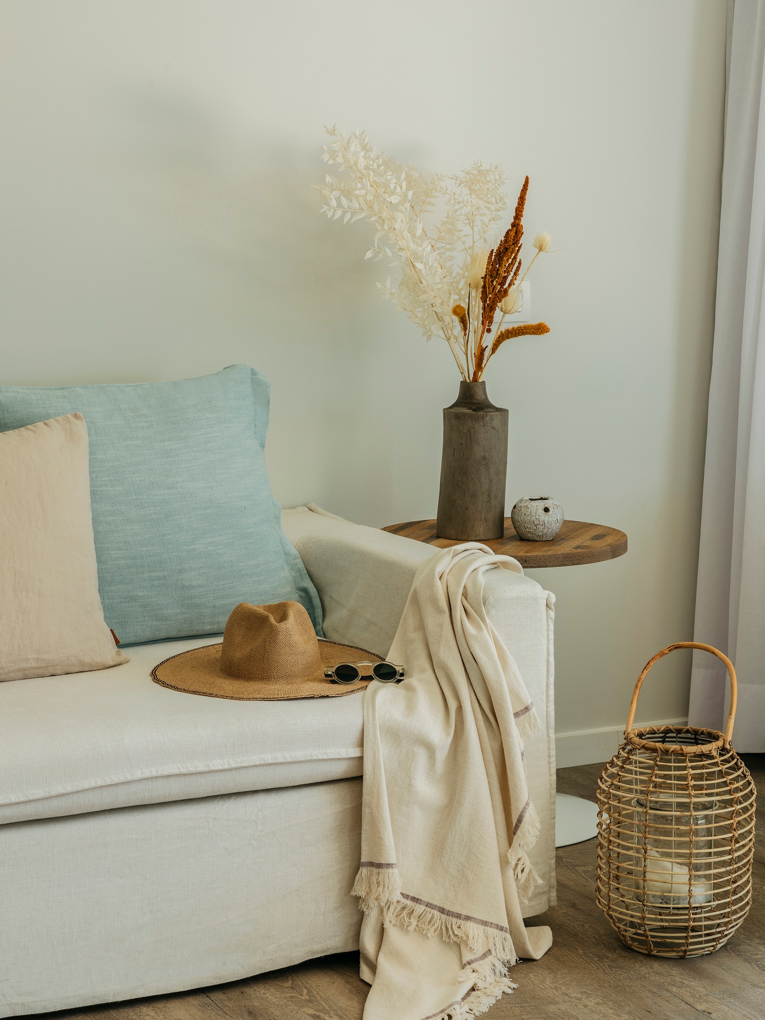 a white couch with a hat and sunglasses on a table