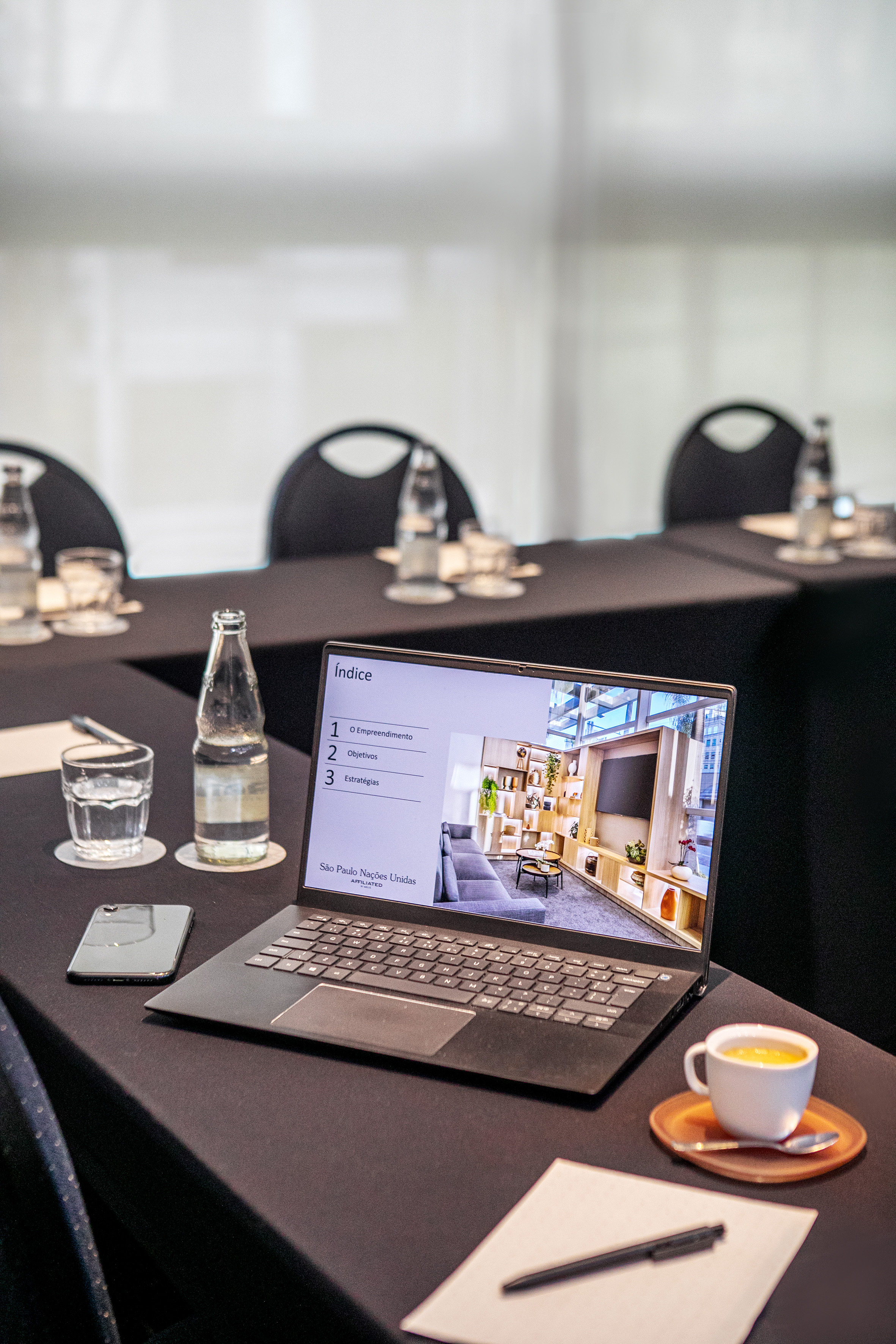Laptop showing modern interior design presentation on a meeting table.