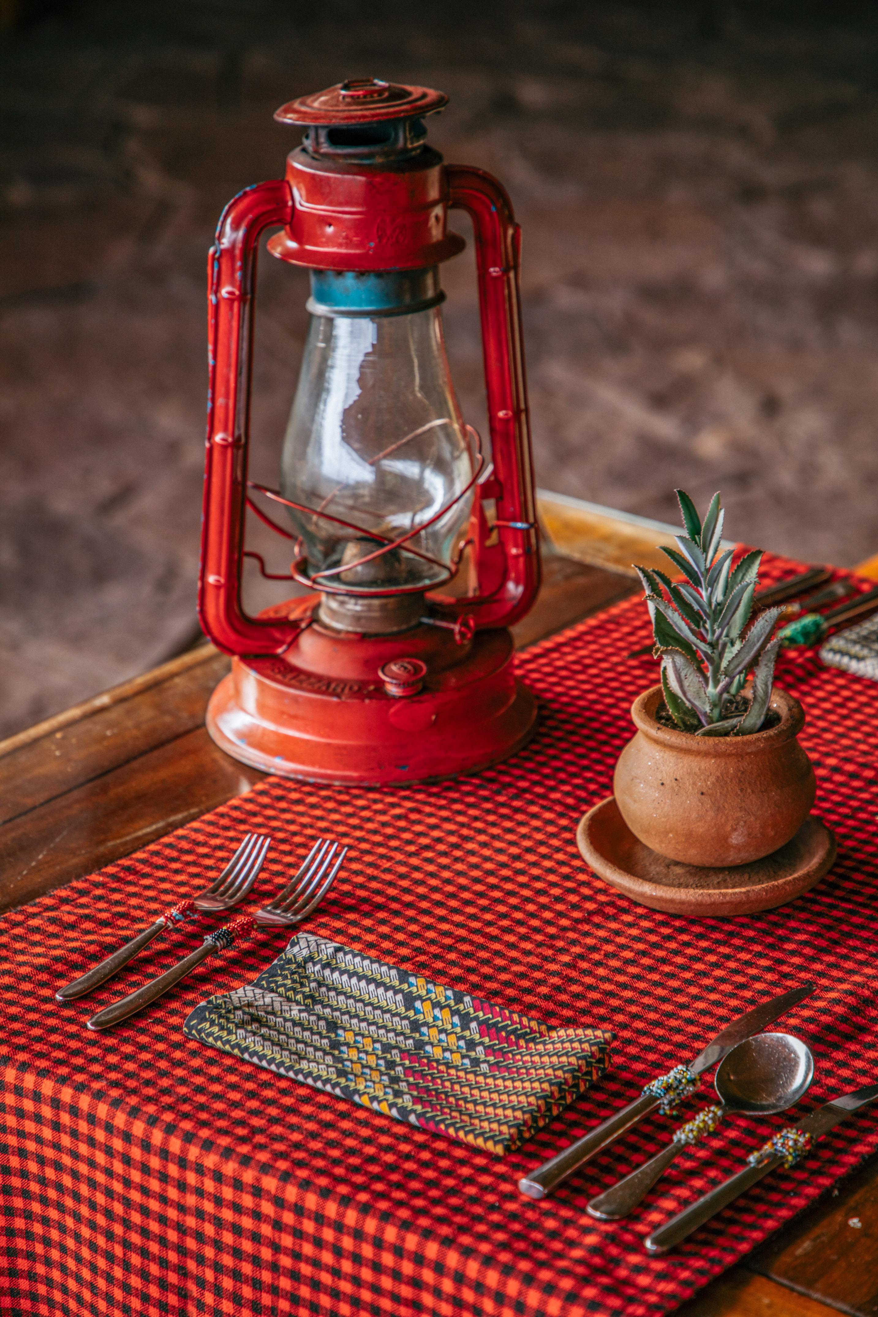 a table with a red lantern and a potted plant
