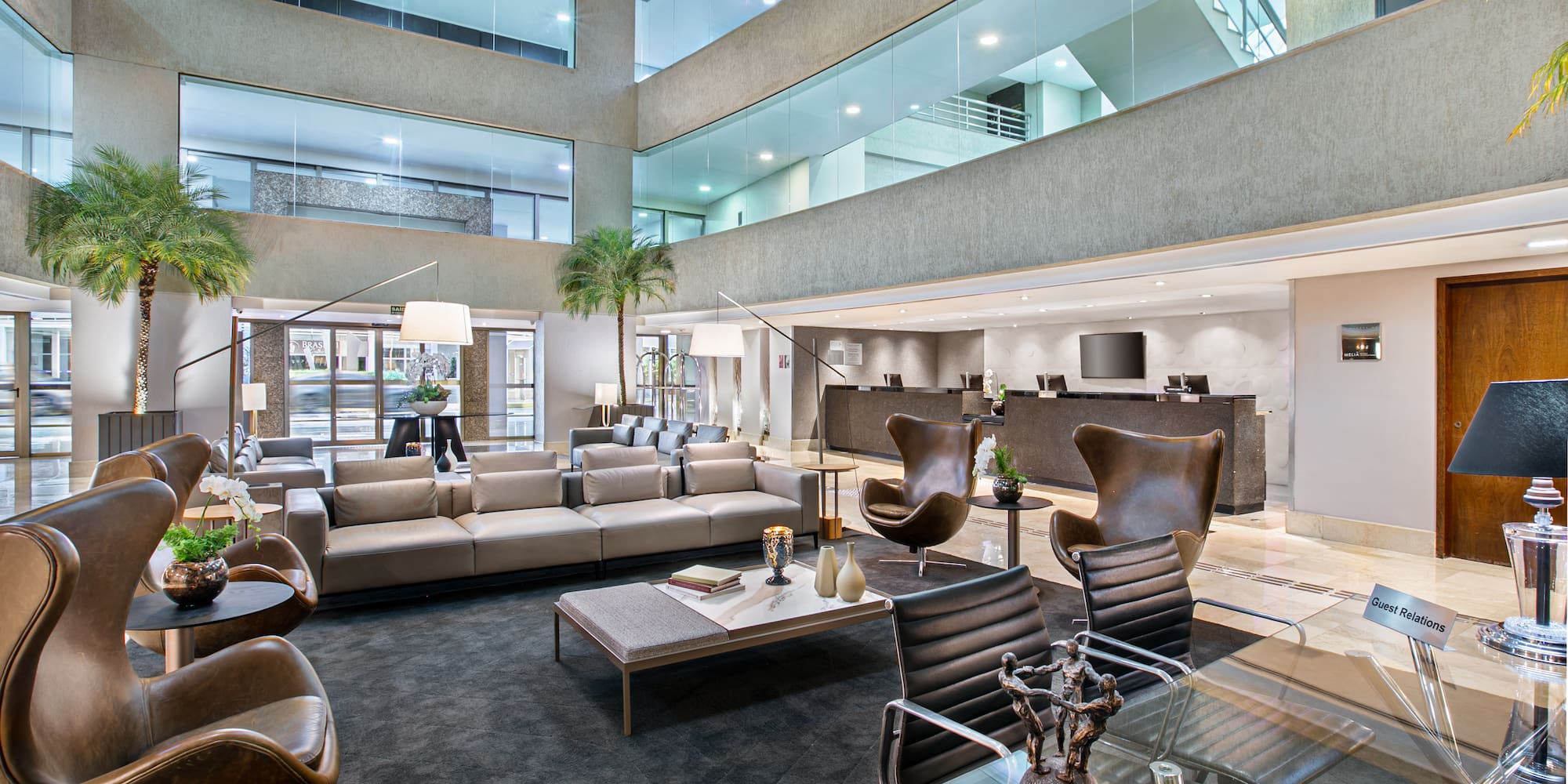 Modern hotel lobby lounge with contemporary leather seating and reception.