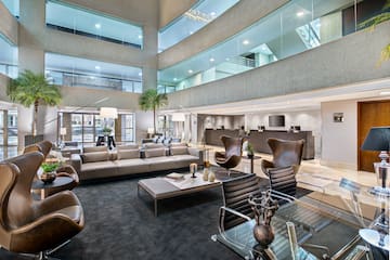 Modern hotel lobby lounge with contemporary leather seating and reception.