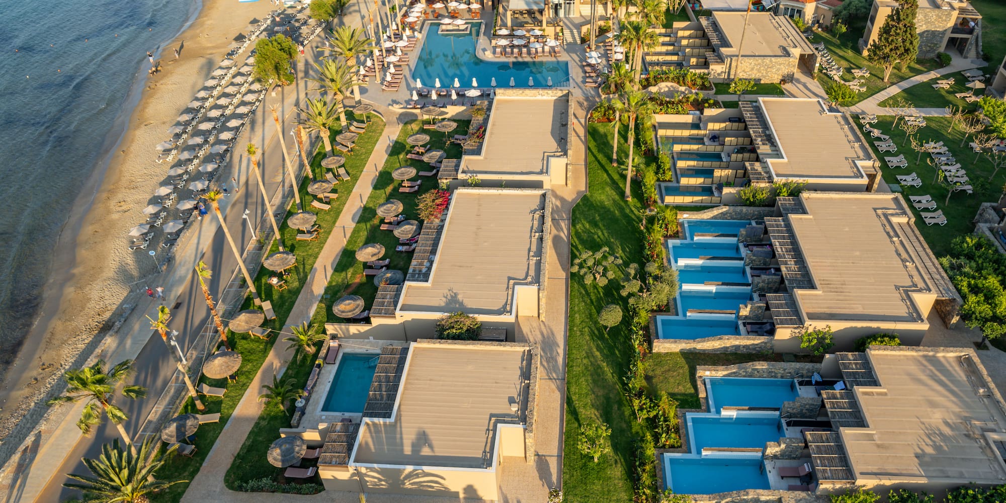 Luxury beach resort with multiple swimming pools, private pools, and palm trees.