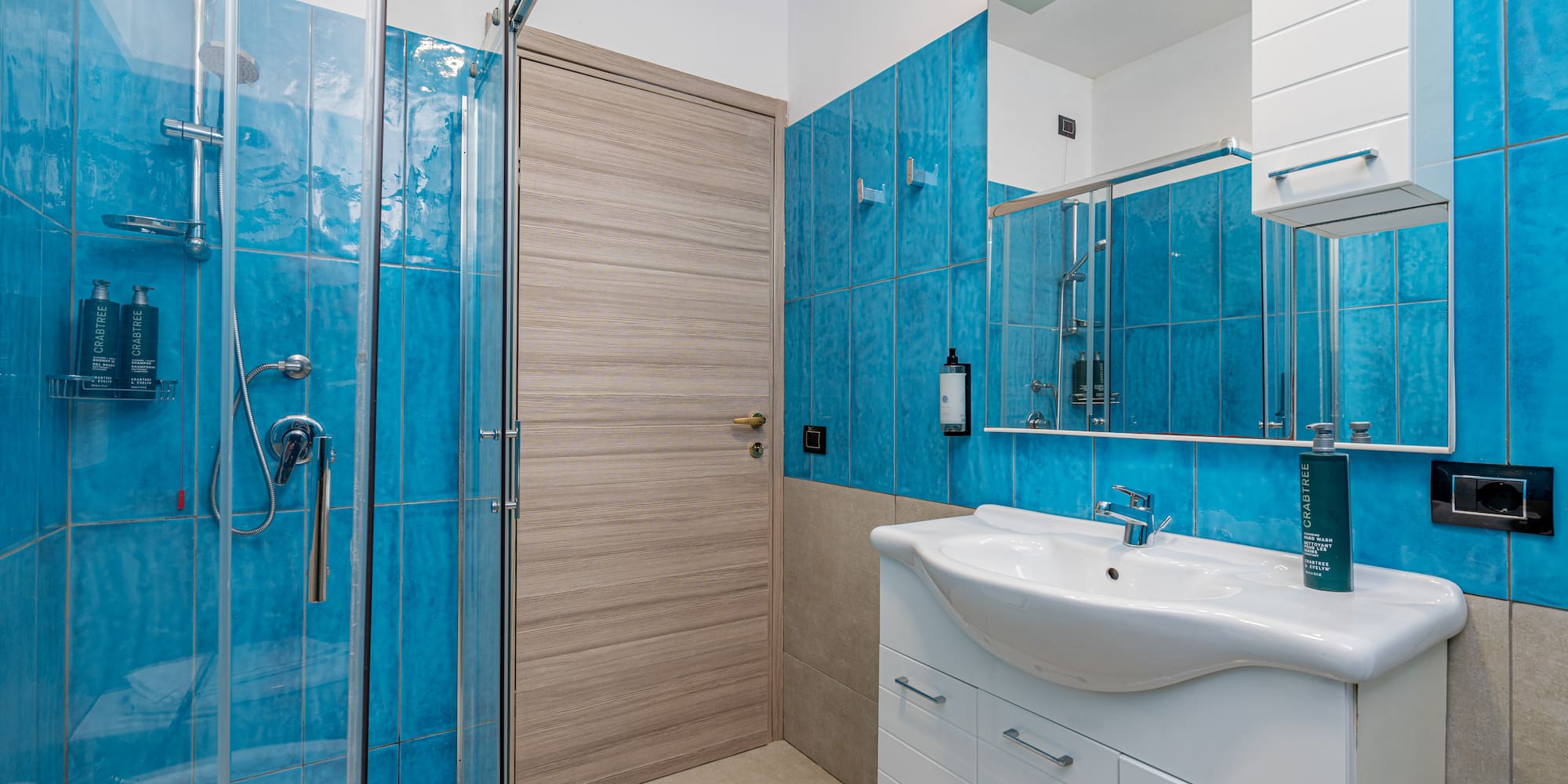 a bathroom with blue tile walls and a sink