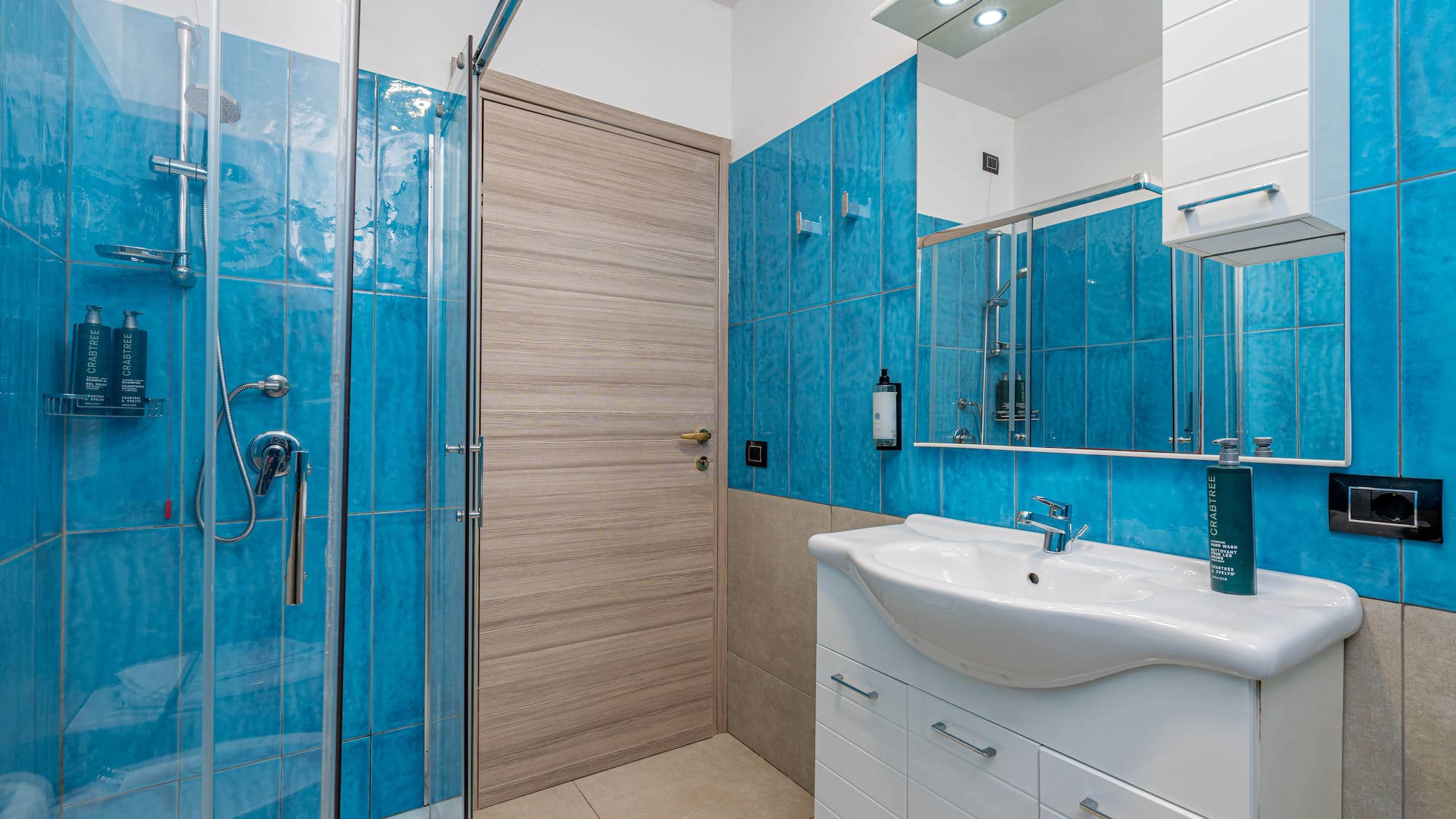 a bathroom with blue tile walls and a sink