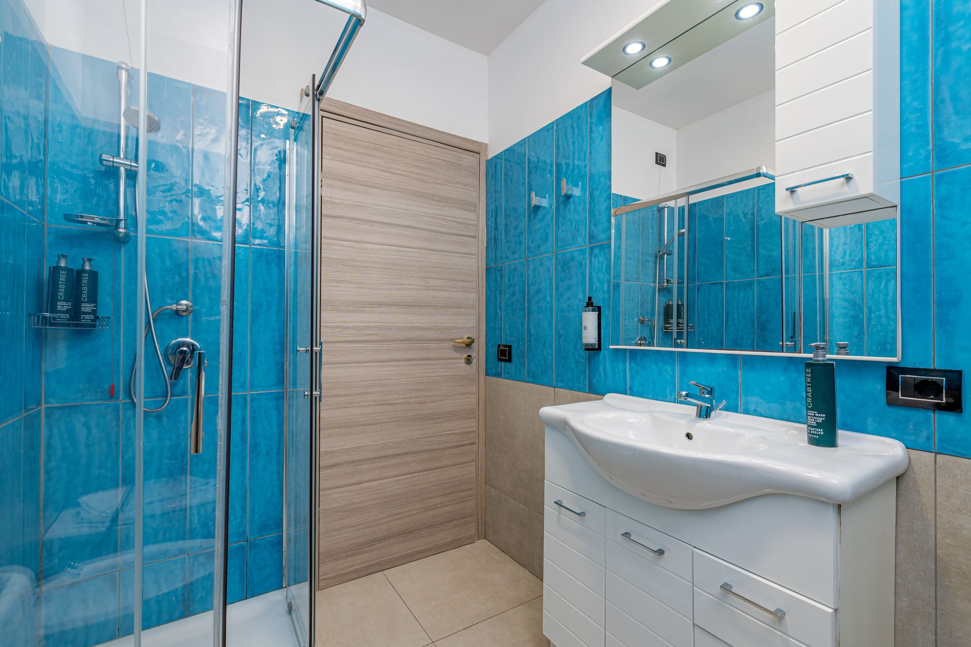 a bathroom with blue tile walls and a sink