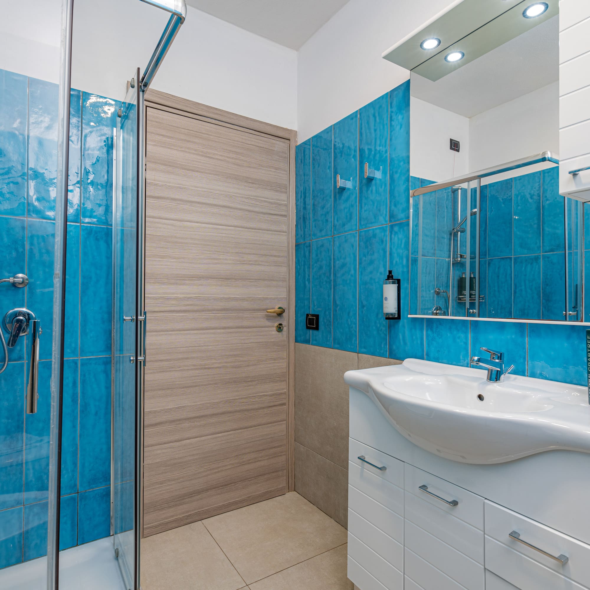 a bathroom with blue tile walls and a sink
