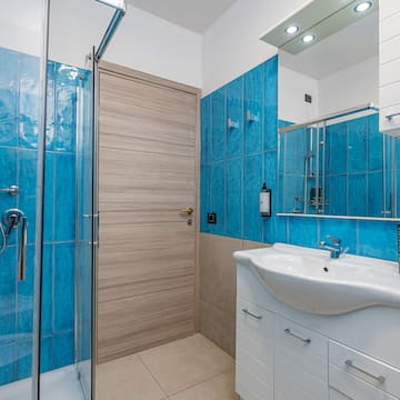 a bathroom with blue tile walls and a sink
