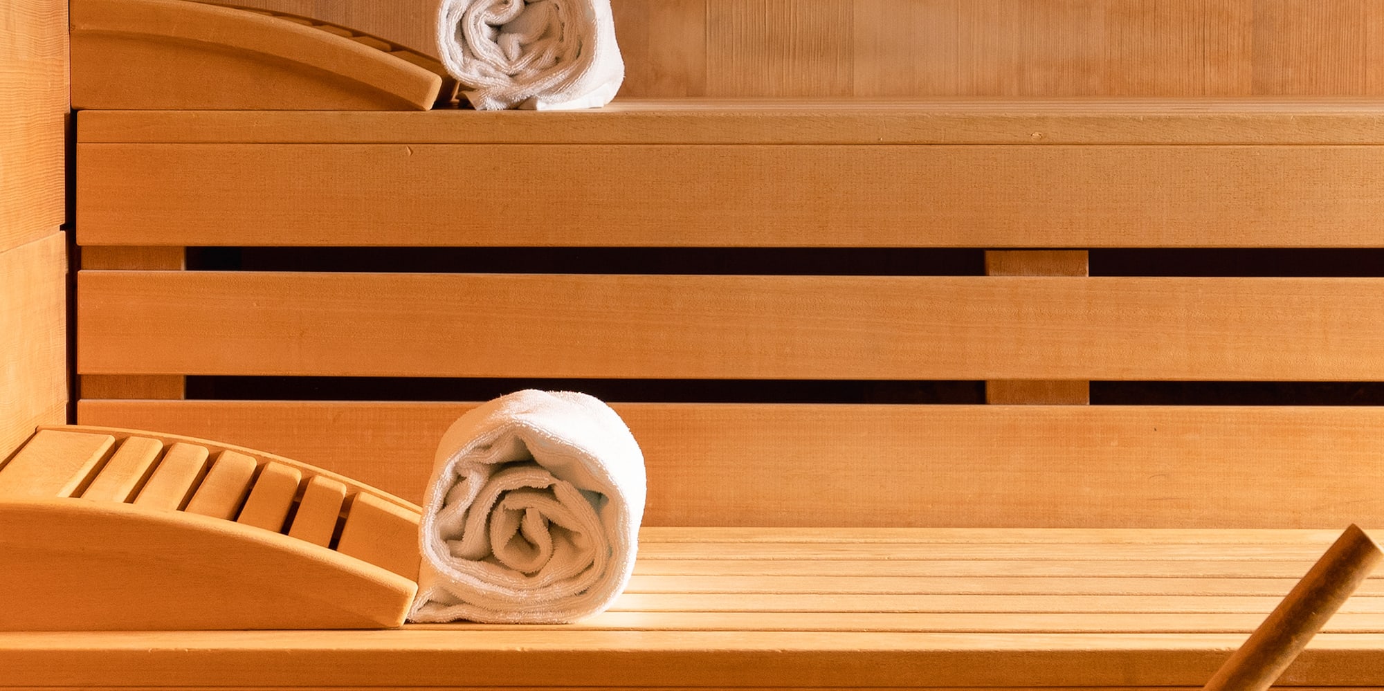 a wooden bench with towels and a bucket