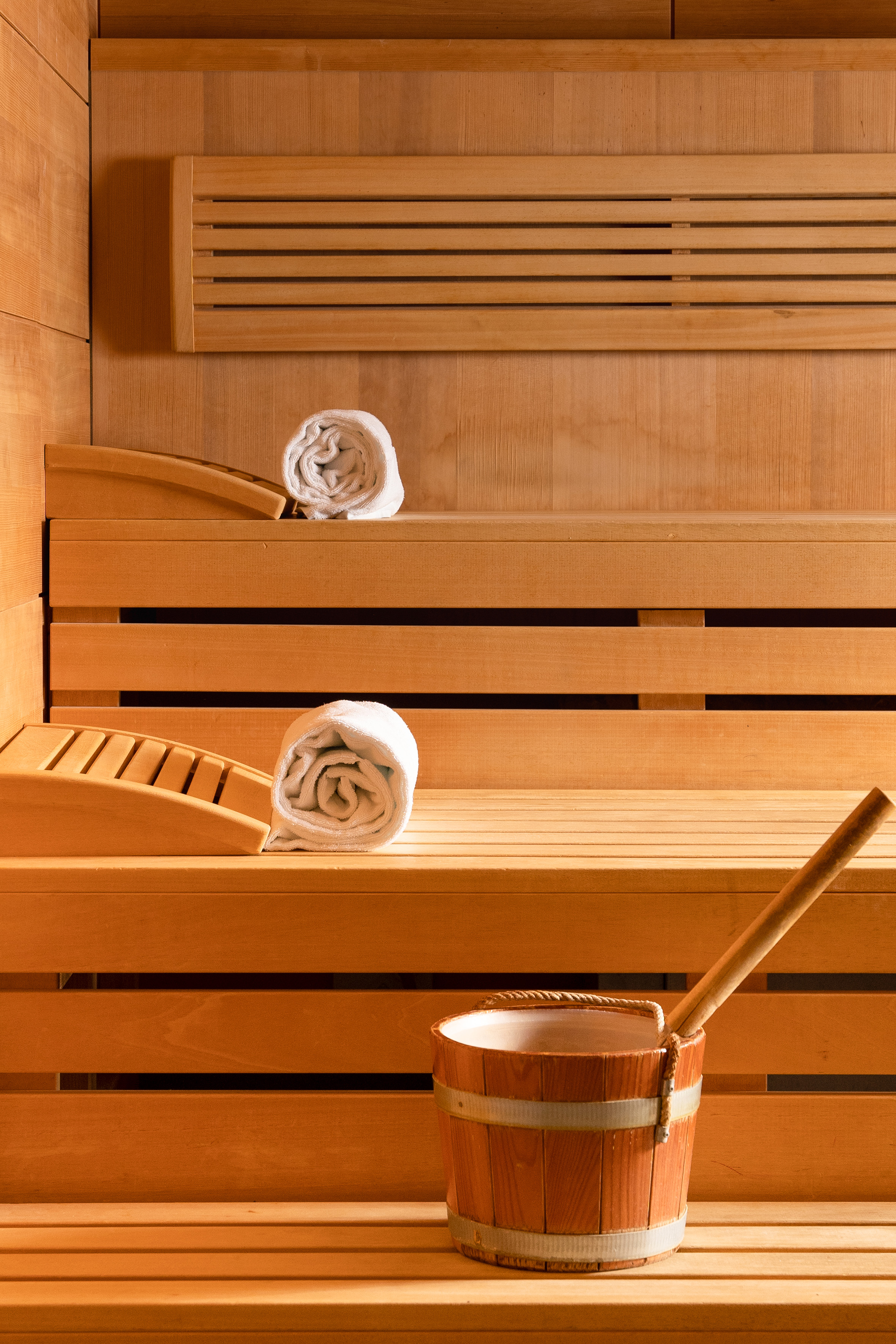 a wooden bench with towels and a bucket