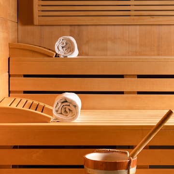 a wooden bench with towels and a bucket