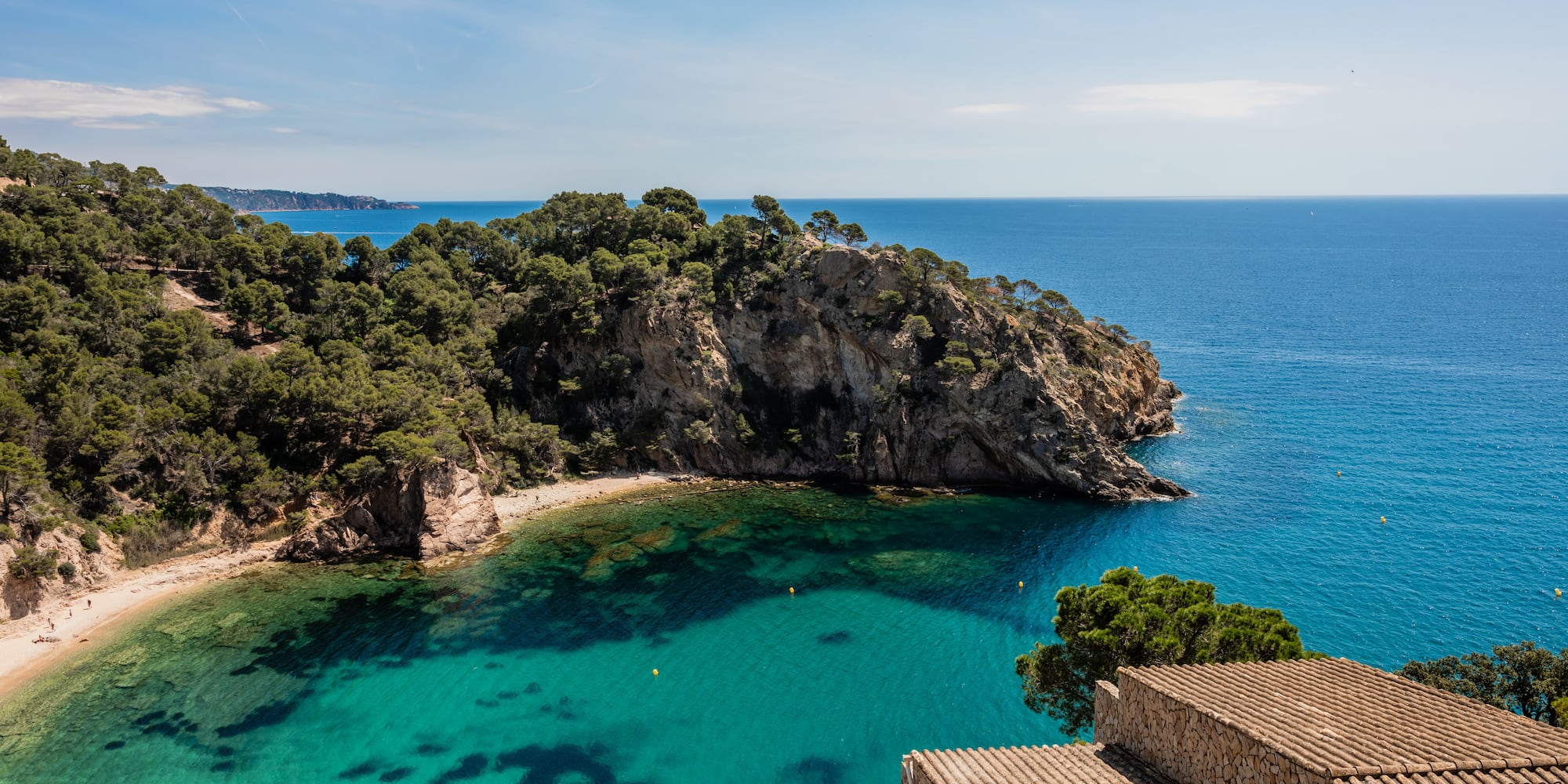 a blue water next to a beach
