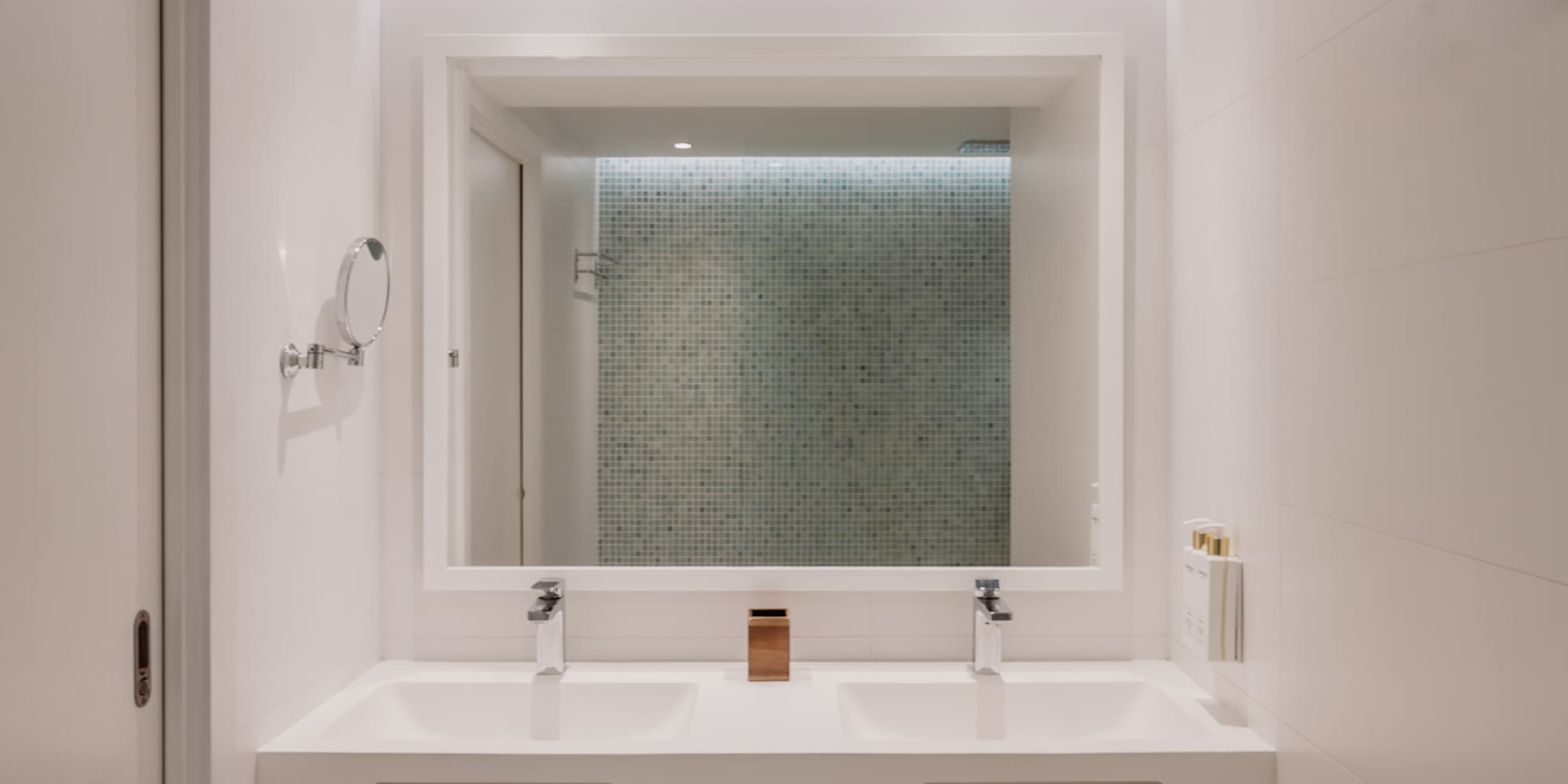 Baño moderno, doble lavabo blanco, espejo iluminado. Diseño minimalista hotel.