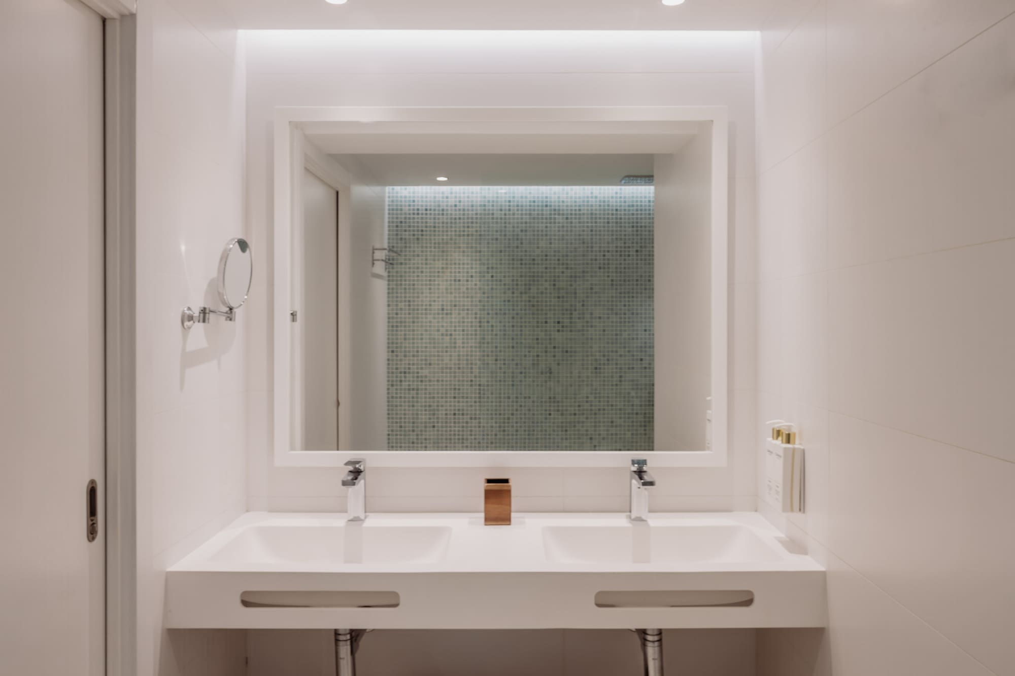 Baño moderno, doble lavabo blanco, espejo iluminado. Diseño minimalista hotel.