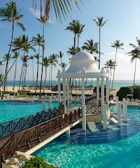 a swimming pool with a gazebo and palm trees