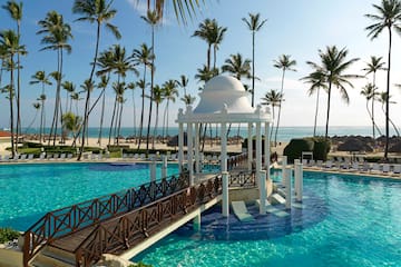 a swimming pool with a gazebo and palm trees