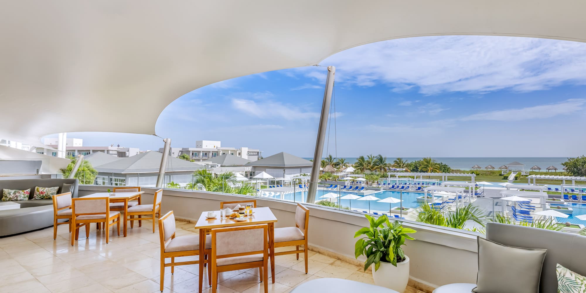 a room with a view of the ocean and a pool