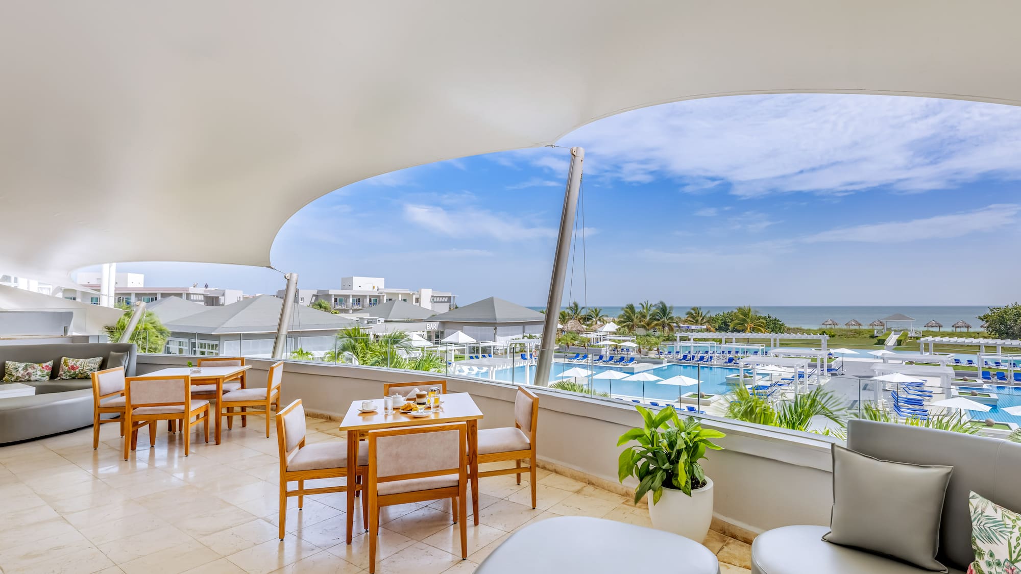 a room with a view of the ocean and a pool