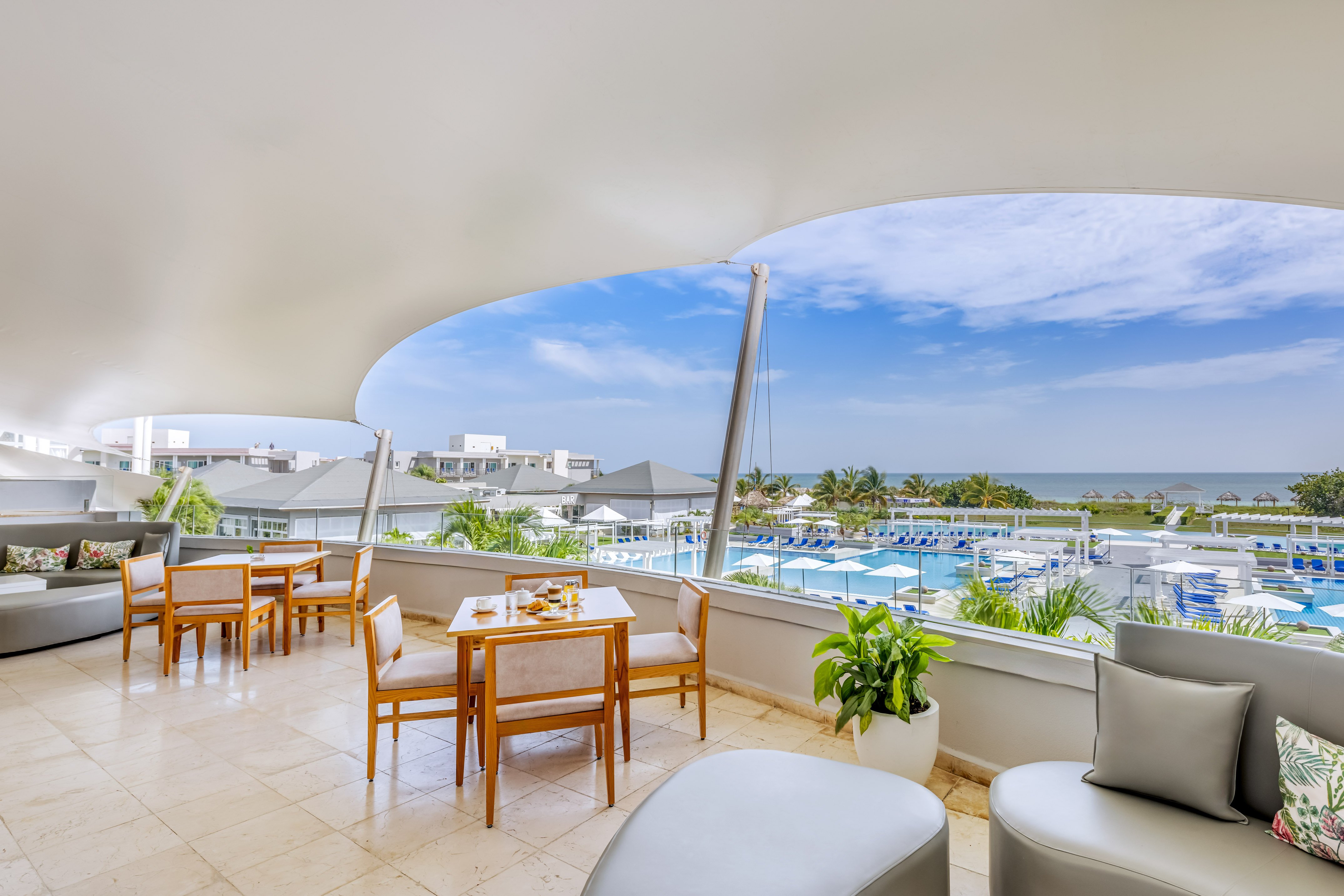 a room with a view of the ocean and a pool