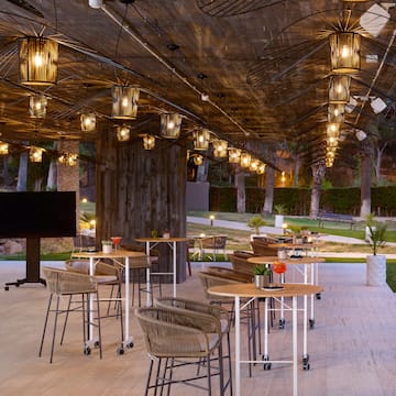 a patio with tables and chairs and a television