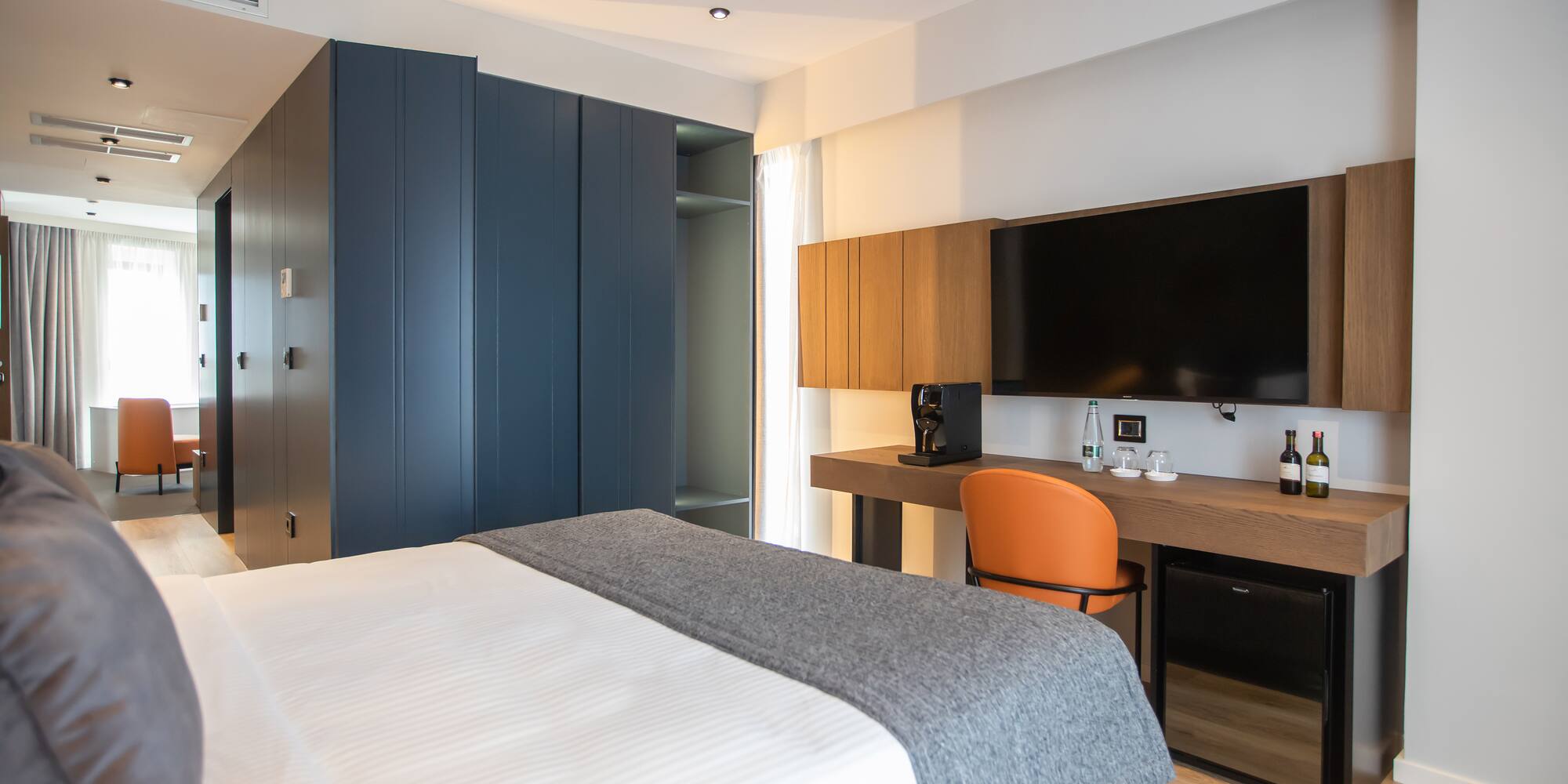 a room with a bed and a desk and a tv