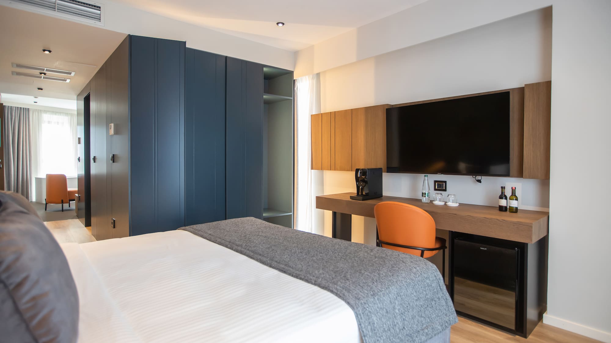 a room with a bed and a desk and a tv