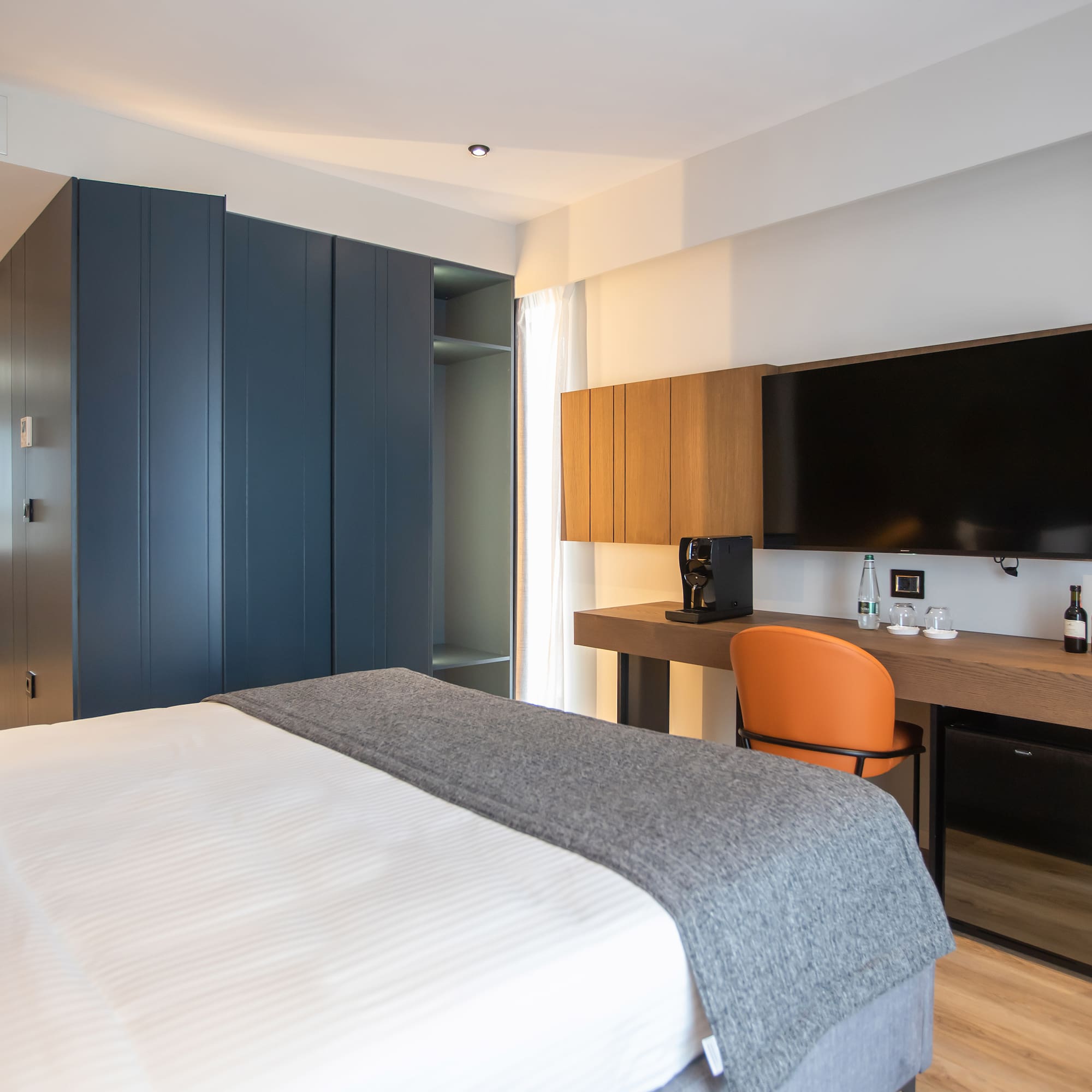 a room with a bed and a desk and a tv