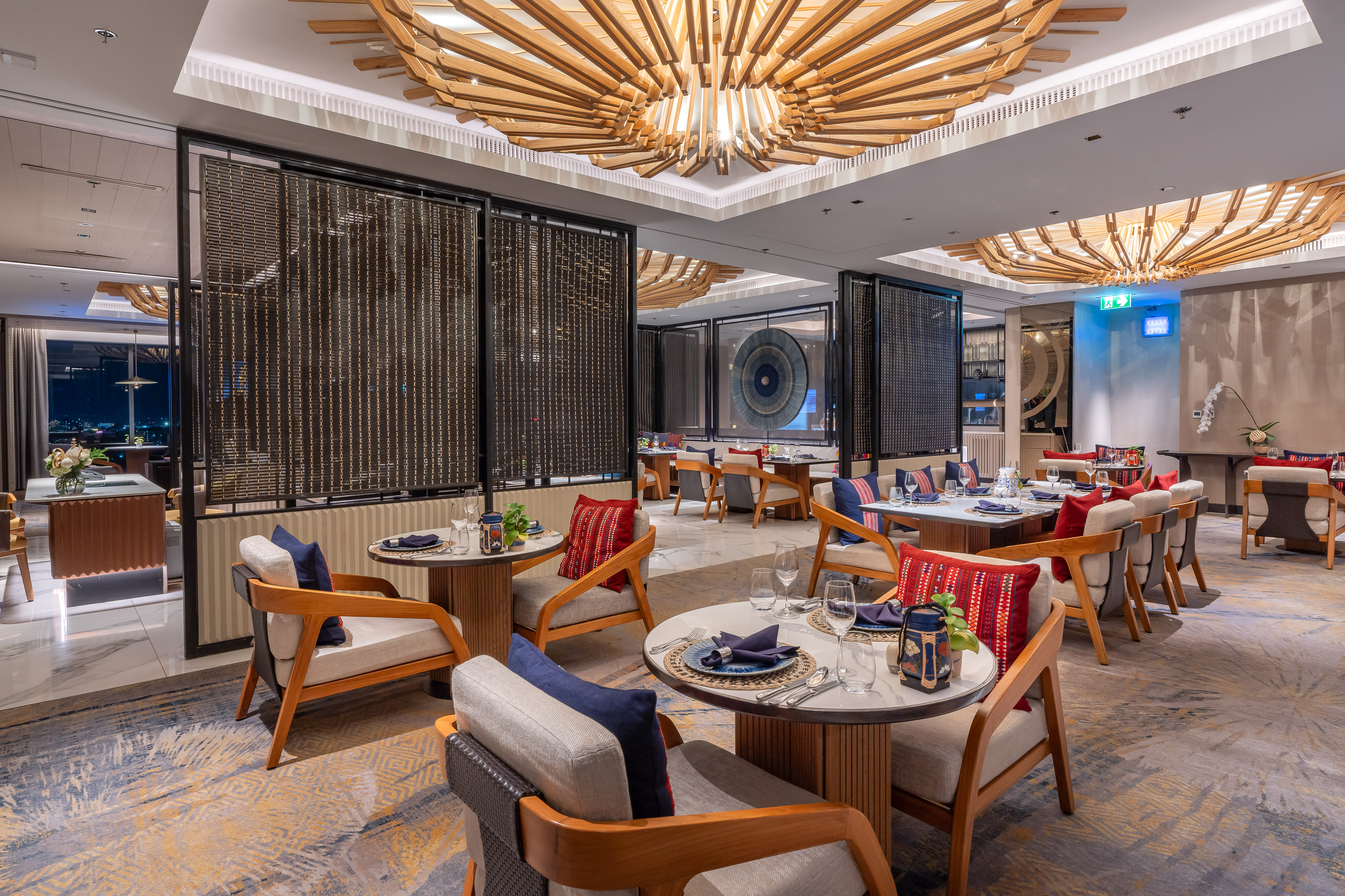 Modern restaurant dining room with distinctive wooden ceiling and set tables.