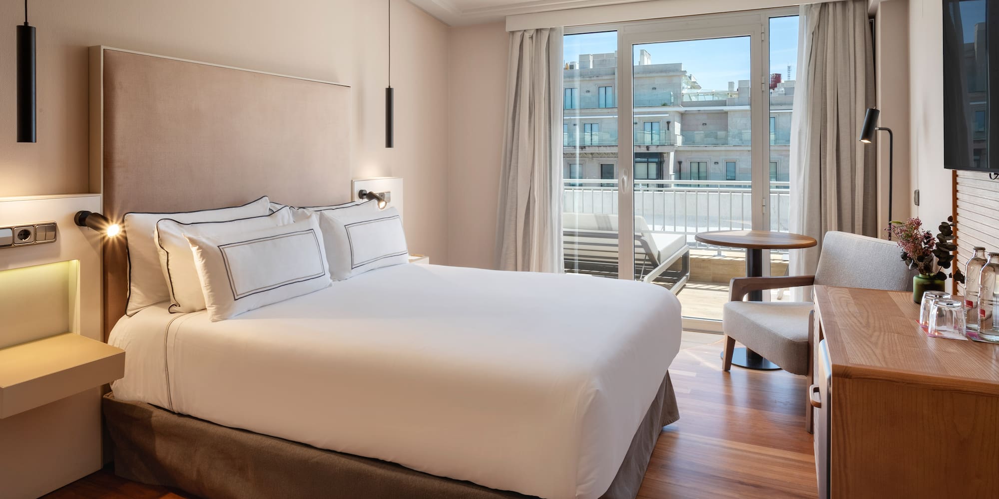 a bed with a chair and a desk in a hotel room