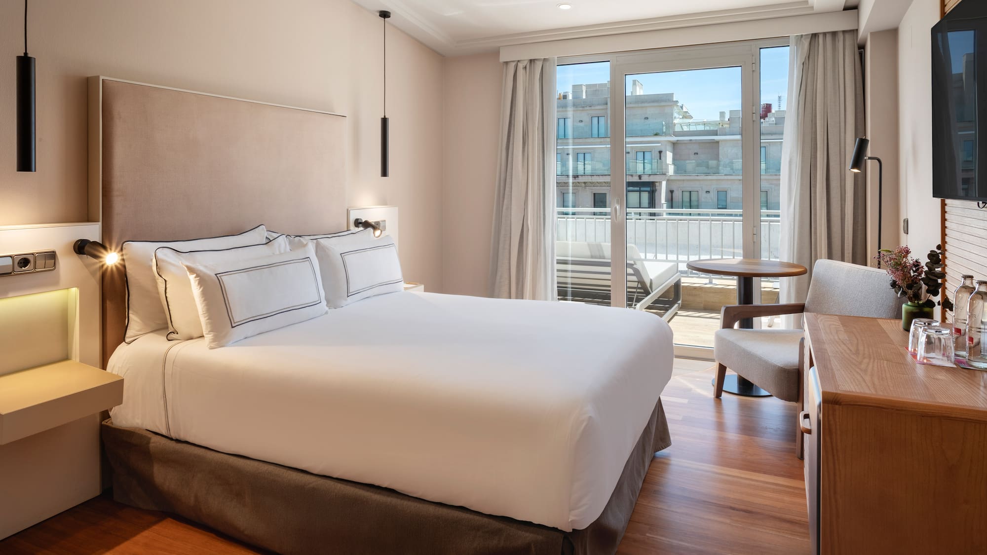 a bed with a chair and a desk in a hotel room