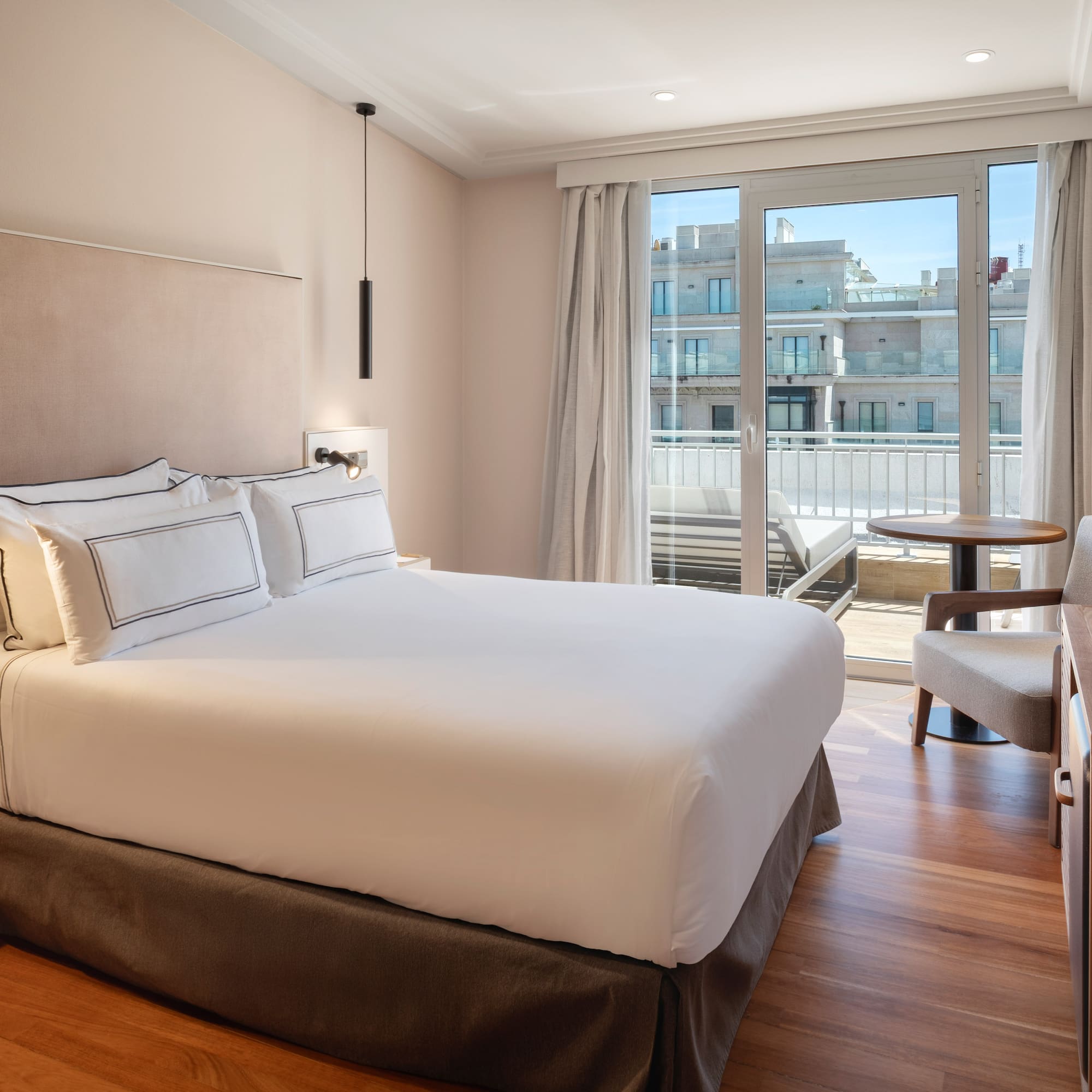 a bed with a chair and a desk in a hotel room