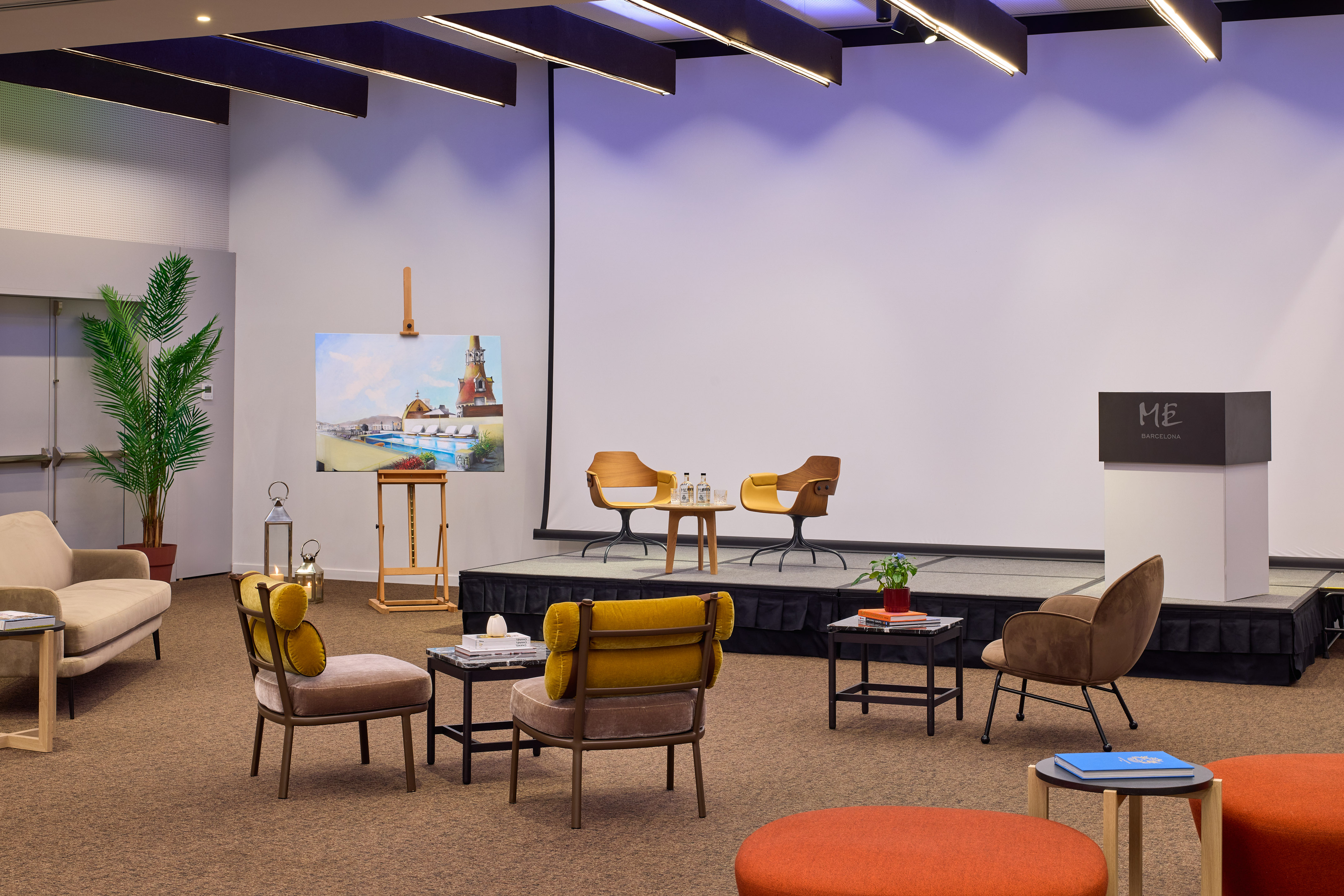 Stylish hotel event space with stage, podium, and modern lounge seating.