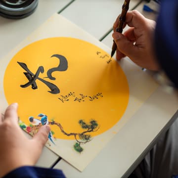 a person writing on a piece of paper