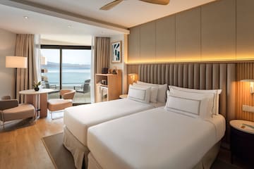 a room with two beds and a table and chairs