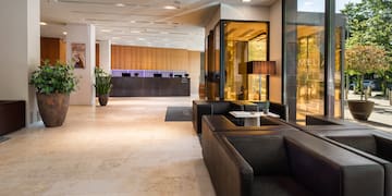 a lobby with black couches and a glass wall