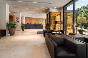 a lobby with black couches and a glass wall