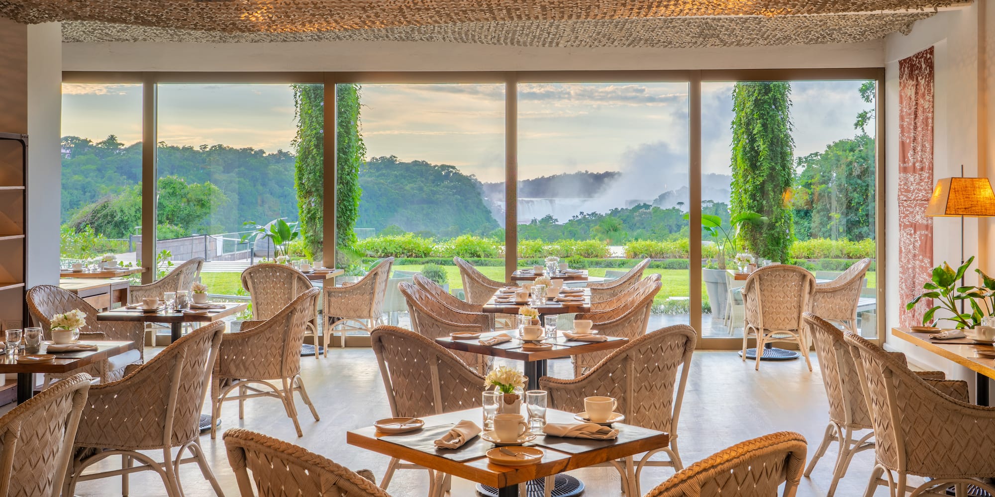 a room with tables and chairs and a view of the mountains