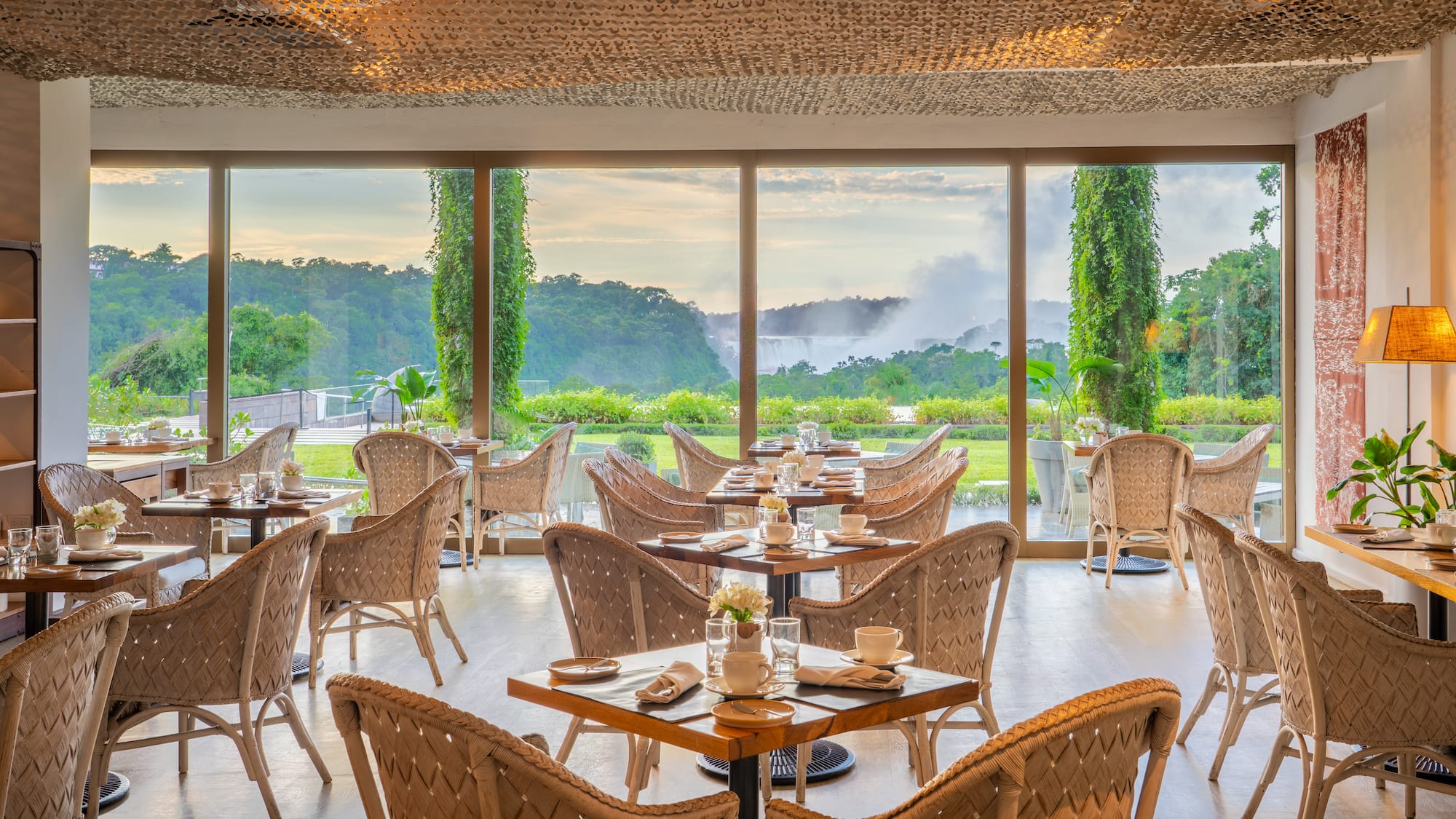 a room with tables and chairs and a view of the mountains